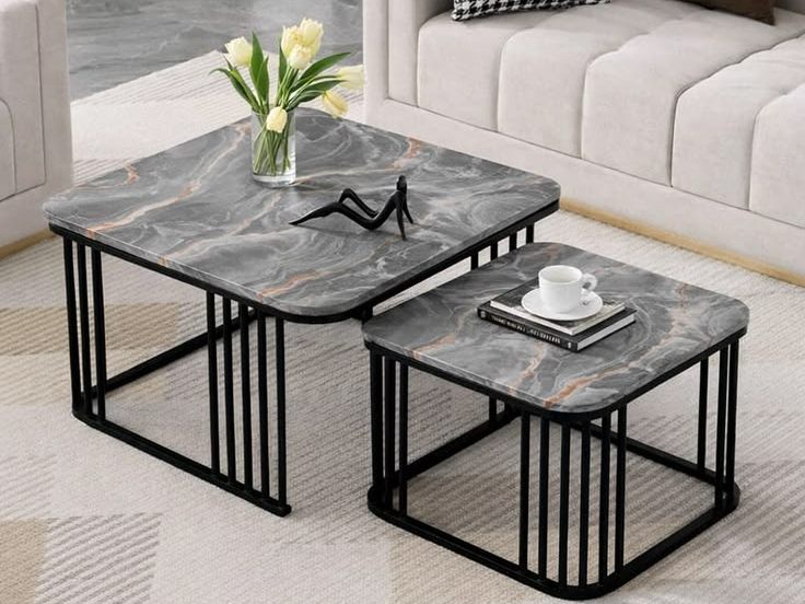 Grey marble top nesting coffee tables with black metal frames beside a sofa